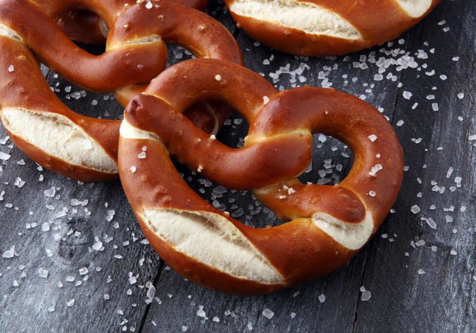 bavarian soft pretzel with rock salt on dark wood background